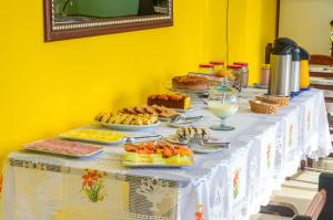 - une table avec un buffet de plats dans l'établissement Pousada Primavera, à Parati