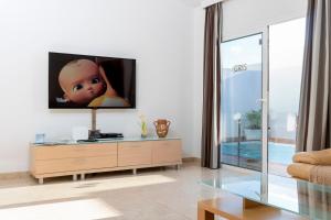 sala de estar con TV de pantalla plana en la pared en Villa Eris, en Puerto del Carmen