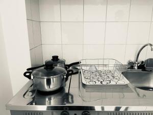 a pot and a strainer on a stove in a kitchen at ALEKA KOTSI ROOMS in Igoumenitsa