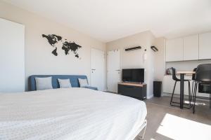a bedroom with a large bed and a tv at Studio-M in Middelkerke