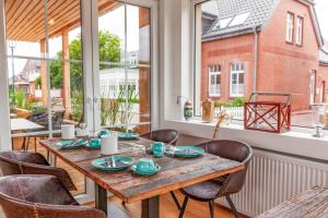 a dining room with a wooden table and chairs at Relitto Boutique und Aparthotel Borkum in Borkum