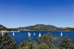 eine Gruppe von Segelbooten auf einem großen Gewässer in der Unterkunft La Casita de Noe con vista al Pantano de San Juan in San Martín de Valdeiglesias