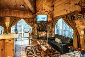 a living room with a couch and a fireplace at The TreeHouse - Rocking Chair Deck with Hot Tub below, Walking Distance to Downtown Helen, Sleeps 5 in Helen