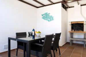 a dining room with a black table and chairs at Villa Eris in Puerto del Carmen