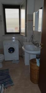 y baño con lavabo y lavadora. en Sole e azzurro en Fiumefreddo di Sicilia