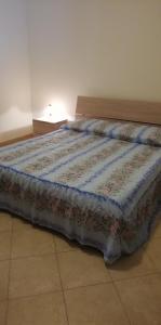 Una cama con edredón en una habitación en Sole e azzurro en Fiumefreddo di Sicilia