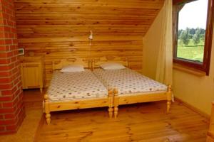 un letto in legno in una camera con finestra di Brīvdienu māja Vīteri a Biksinīki