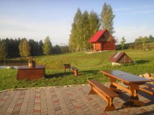 une table de pique-nique et une grange dans un champ dans l'établissement Brīvdienu māja Vīteri, à Biksinīki