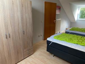 1 Schlafzimmer mit 2 Betten und einem großen Holzschrank in der Unterkunft Ferienhäuser Schlossberg in Zandt