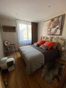 a bedroom with a large bed with red pillows at Bliss’appart boulogne/mer logement avec balnéothérapie in Boulogne-sur-Mer