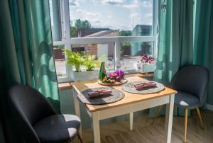 a table with two chairs in front of a window at Sweet XS in Boryspilʼ