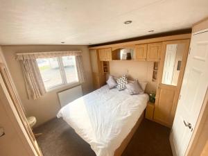ein kleines Schlafzimmer mit einem Bett in einem Wohnwagen in der Unterkunft Luxury 2 Bedroom 2 bathroom Caravan-small sofa 1 pers in Saint Osyth + 17 Fotos