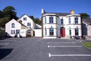 a white house sitting in front of a house at Burford Lodge Guest House in Ardglass