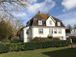 ein weißes Haus mit schwarzem Dach in der Unterkunft Villa Friedericia - Whg4 in Wyk auf Föhr