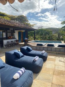 a patio with two blue couches and a swimming pool at Pousada Blanca Mar in Búzios