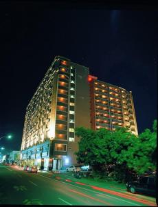 un gran edificio en una calle de la ciudad por la noche en Kenting Holiday Hotel en Hengchun