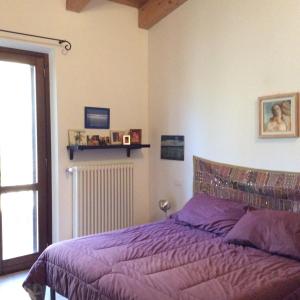 um quarto com uma cama roxa e uma janela em Appartamento Matteo e Daniela em San Leo