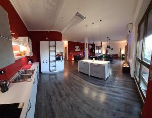 a large kitchen with white cabinets and a hard wood floor at SPAZIO-CONFORT-FITNESS in Piombino