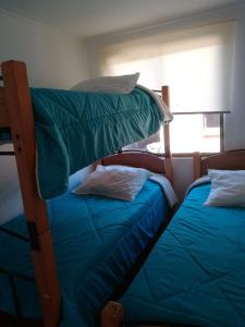 a bedroom with two bunk beds and a window at Cabañas con piscina donde Thomas in La Serena +21 photos