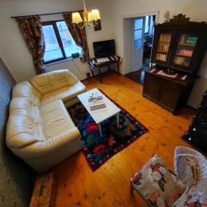 Una sala de estar con un sofá blanco y una mesa. en Feel Free House, en Stulpicani