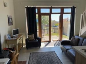 a living room with a couch and a desk with a computer at Bike Shed - Beautiful 1-Bed Cottage in Shorwell in Shorwell