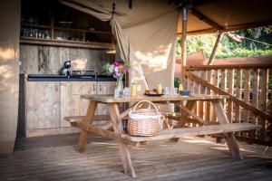 a picnic table with a basket on top of it at Lodges des Grands Chênes in Andelarrot