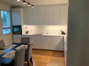 a kitchen with white cabinets and a table and chairs at Majutus Peetris in Petrikyula