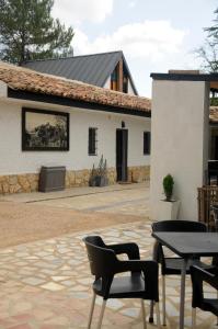 een patio met stoelen en een tafel voor een gebouw bij Villa Caramel in Villalba de la Sierra