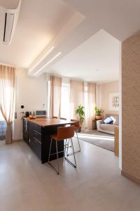 Il comprend une cuisine et un salon avec une table et des chaises. dans l'établissement Sunset House - Smart House - Milano MiCo, à Milan