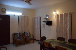 a dining room with a table and chairs and a tv at Charisma Residence Syariah in Surabaya