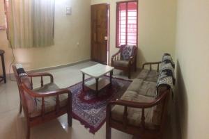 een woonkamer met stoelen, een bank en een tafel bij Charisma Homestay in Surabaya
