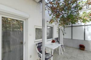 a patio with a table and chairs and a window at Hajnalház Apartments in Balatonfüred