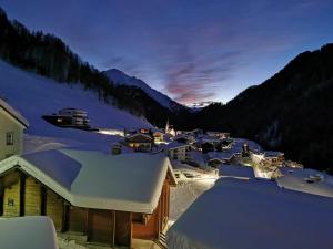 a town covered in snow at night with mountains at Haus Crestas in Samnaun