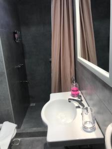 Un baño con lavabo blanco y ducha. en La Casita, en Carhué