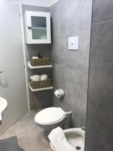 een badkamer met een wit toilet en een wastafel bij La Casita in Carhué