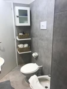 Un baño con un inodoro blanco y un lavabo. en La Casita, en Carhué