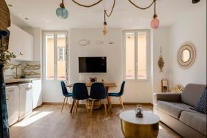 a living room with a couch and a table and chairs at Appartement le Quai du Port Cassis parking clim in Cassis