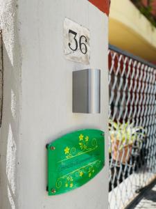 um sinal verde na lateral de um edifício em Il giardino di Iole Via Giovanni Amendola n36 em Sassari