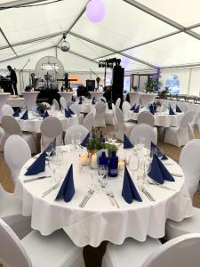 a set up marquee with white tables and blue napkins at Boutique Hotel Goldene Henne in Wolfsburg