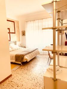 um quarto com uma cama, uma secretária e uma janela em Il giardino di Iole Via Giovanni Amendola n36 em Sassari
