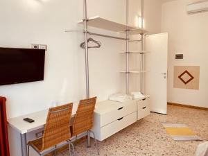 a room with a desk with two chairs and a tv at Il giardino di Iole Via Giovanni Amendola n36 in Sassari