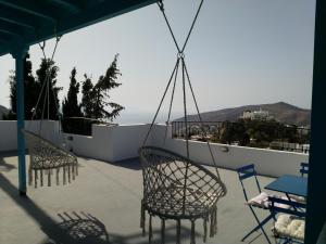 a patio with chairs and tables and a view of the ocean at Villa Fenia in Aegiali