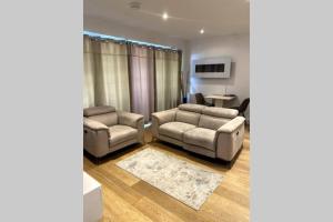 a living room with two couches and a table at Luxury 1 Bedroom Apartment with Netflix & Parking in Borehamwood