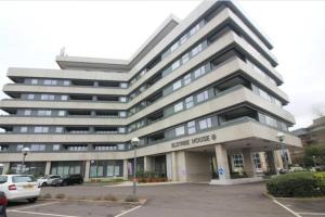 a large office building with a parking lot at Luxury 1 Bedroom Apartment with Netflix & Parking in Borehamwood