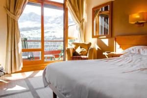 a bedroom with a bed and a large window at Exceptional 3 bed Penthouse with fireplace and stunning views in Flaine +112 photos