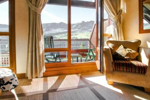 a room with a chair and a large window at Exceptional 3 bed Penthouse with fireplace and stunning views in Flaine