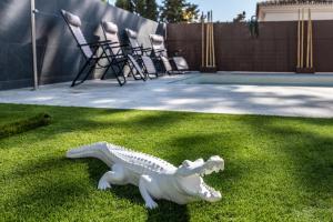 a white plastic dinosaur on the grass near a tennis court at THE JUNGLE VILLA - 4BDR Private Pool/Jacuzzi/BBQ in Benalmádena