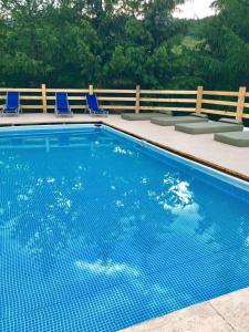 a blue swimming pool with chairs and a fence at Рандеву in Slavske +25 photos
