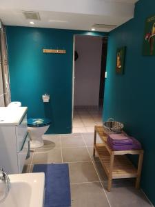 a bathroom with a toilet and a blue wall at LE CEDRE BLEU in Saint-Michel-sur-Meurthe