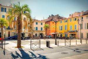 a street with palm trees and tables and buildings at Little Pendjari - Duplex - Port - HOST PROVENCE in La Seyne-sur-Mer